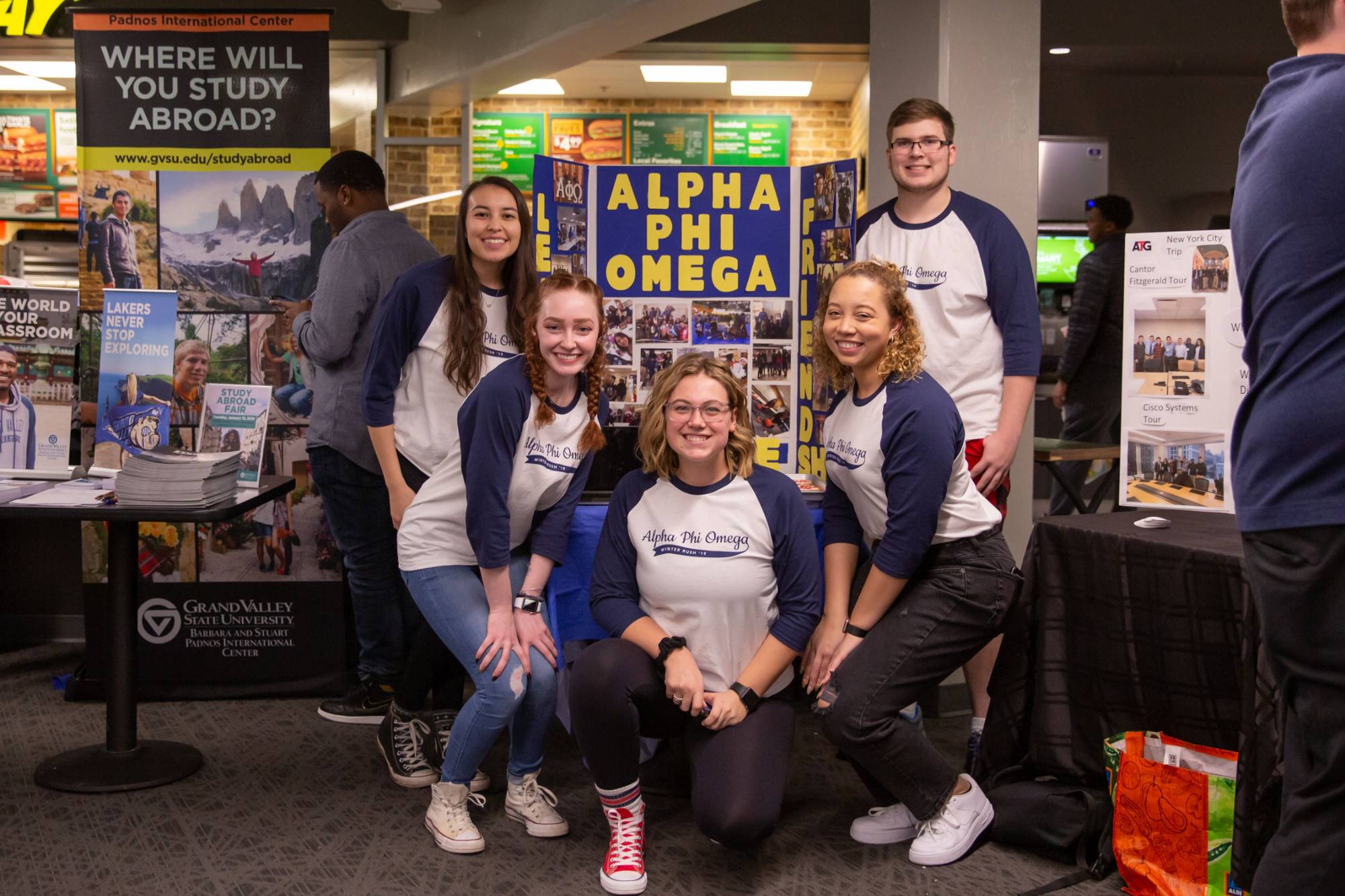 Students in Alpha Phi Omega standing in front of their sign